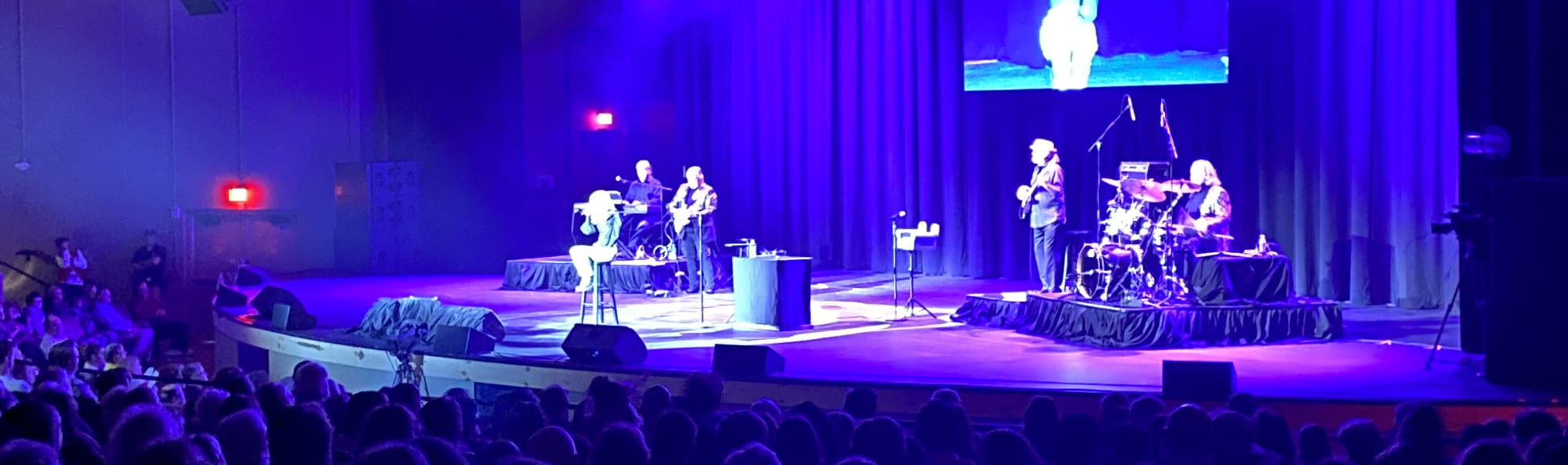 signer on stage in chair washed out by the lights Champaign